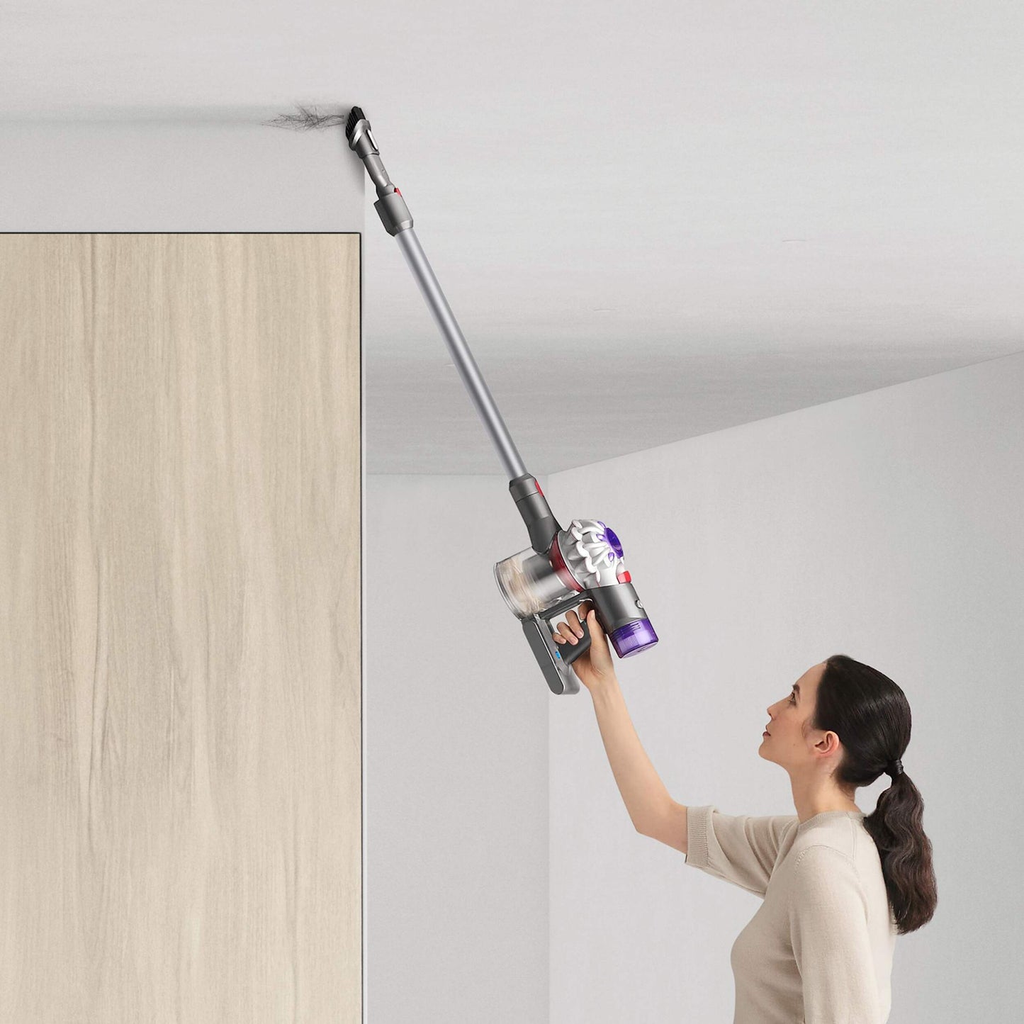 Girl vacuuming dirt off ceiling with combination tool Dyson V7 Advanced