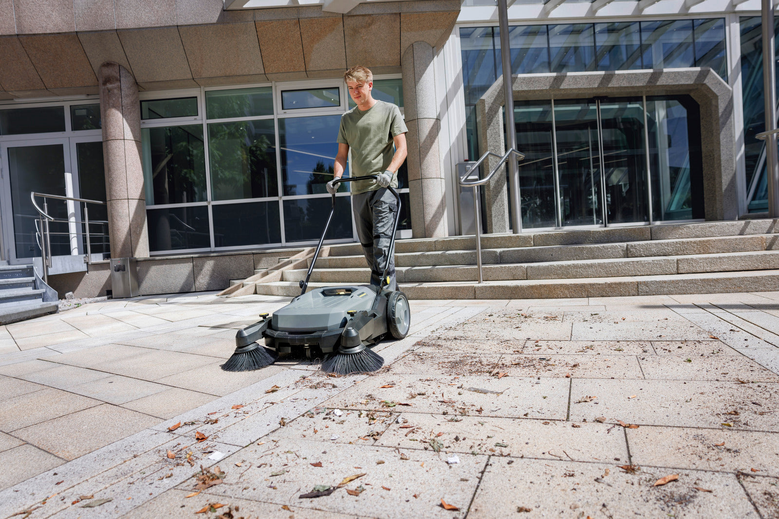 Karcher KM 70/20 C 2SB Manual Walk-Behind Compact Floor Sweeper W/ Dual Brushes sweeping leaves